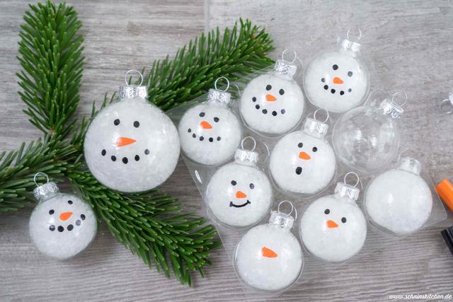 Niedliche Bastelidee für Kinder: Schneemannkugeln aus Bastelpompoms und Filzstoff